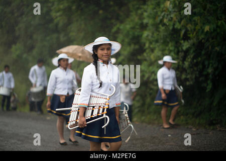 Ein junges Mädchen Ngäbe-Bugle Paraden durch starken Regen mit ihrem Marching Band, an der Panama Ngäbe-Bugle Comarca. Stockfoto