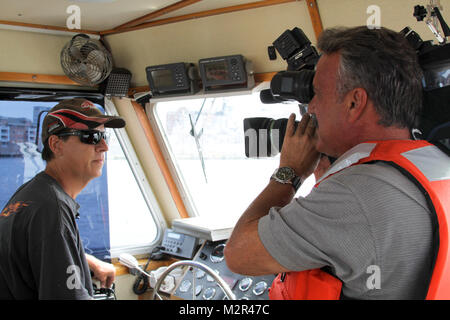 Kunst Kohn, von WELLENFÖRMIG - TV 10, Interviews Jeff Gibbs, ein Norfolk Bezirk Boot Kapitän, während er Patrouillen der Elizabeth River auf der Suche nach Verschmutzungen im Wasser nach dem Hurrikan Irene der Region getroffen. Die Hampton Roads Drift Ausbau Programm, das das ganze Jahr lange dauert, stellt die Bundesregierung in der Navigation für die kommerzielle Schifffahrt und Segler sicher ist. (U.S. Armee Foto/Patrick Bloodgood) 110830-A-OI 229-003 durch norfolkdistrict Stockfoto