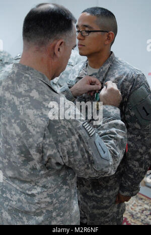 Oberst Paul Calvert, Links, Kommandant der 2. "Dagger" beraten und unterstützen Brigade, 1 Infanterie Division, United States Abteilung - Zentrum und ein Athen, Ga, Eingeborener, Stifte ein Army Commendation Medal auf der Uniform der Sgt. Steven Salas, Sat-Operator mit Firma B, "Greif" Spezielle Truppen Bataillon, 2. AAB, 1. Inf. Div., USD-C und einem Woodbridge, Virginia, Eingeborener, in Anerkennung von Salas Gewinnen der Brigade Soldat des Jahres Wettbewerb Sept. 27, 2011. Salas ursprünglich gewann Soldat der Viertel mit den Rang der Spezialist und hat in der Zwischenzeit gefördert worden, die zeigen, dass Exzellenz ist Gener Stockfoto