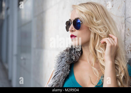 Junge Frau in der Nähe Sonnenbrillen in der Stadt, Porträt Stockfoto