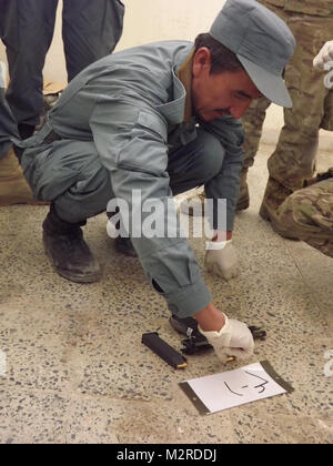 Ein Mitglied der afghanischen Polizei dissambles 9mm während eines Crime Scene Investigation Klasse bei der Dand Bezirk Mitte in Kandahar, Afghanistan, 17.November. Während die Klasse Soldaten aus der Sicherheitskräfte Hilfe Team 205th Military Police und Task Force arktische Wölfe, 1 Stryker Brigade Combat Team, 25 Infanterie Division, lehrte ANP, wie man richtig sichern, dokumentieren und fotografieren Beweis an Tatorten. (U.S. Armee Foto: Sgt. Thomas Duval 1/25 SBCT Public Affairs) 111117-A-werden 343-004 von 1 Stryker Brigade Combat Team arktische Wölfe Stockfoto