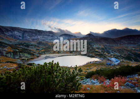 Hohen Berg Zirkus See in der bulgarischen Rila-gebirge, atemberaubenden Sonnenuntergang über dem Winter peak Stockfoto