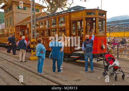 Touristen fotografieren der Straßenbahn zwischen Sóller und Port de Sóller, Carrer de la Marina, seaside Street, Port de Soller, Mallorca, Balearen, Stockfoto