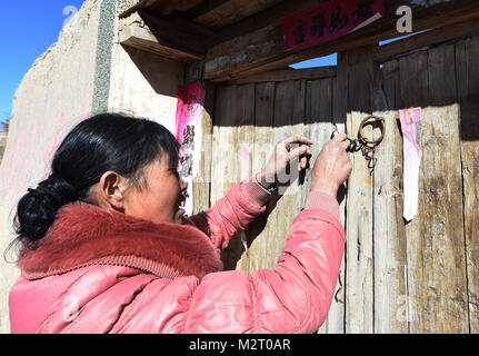 (180208) - GULANG, Februar 8, 2018 (Xinhua) - Xu Cun sperrt die Tür ihres alten Hauses im Dorf Shicheng Huangyangchuan County im Gulang im Nordwesten der chinesischen Provinz Gansu, Feb 6, 2018. Xu Cun, mit einem behinderten Mann krank im Bett und Schwiegermutter über 70, ist das Rückgrat ihrer Familie. Vor der diesjährigen Frühlingsfest, Xu und ihre Familienmitglieder waren beschäftigt mit Umzug. Mit der Hilfe der lokalen Regierung die Linderung von Armut Projekt, Xu verbrachte weniger als 40.000 Yuan (ca. 6.314 US-Dollar) auf den Aufbau, die Dekoration und Einrichtung Ihrer neuen Wohnung von 100 Quadratmetern in einem Umzug communi Stockfoto