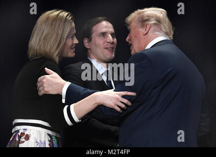 Washington, District of Columbia, USA. 8 Feb, 2018. Präsidenten der Vereinigten Staaten Donald J. Trumpf, rechts, umarmt US Army Major Scott Smiley (im Ruhestand), Mitte, die während des Irak-kriegs geblendet war, und seine Frau Tiffany, Links, während der Nationalen Gebetsfrühstück, Februar 8, 2018, in Washington, DC. Tausende aus der ganzen Welt nehmen an der jährlichen ökumenischen Versammlung und jeder Präsident, seit Präsident Dwight Eisenhower die Veranstaltung gerichtet hat. Credit: Mike Theiler/Pool über CNP Credit: Mike Theiler/CNP/ZUMA Draht/Alamy leben Nachrichten Stockfoto