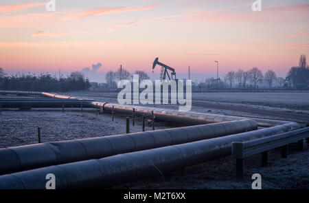 Emlichheim, Deutschland. 8 Feb, 2018. Ein Blick auf die Silhouette eines Pferdes - Kopf Pumpe bei Sonnenaufgang in Emlichheim, Deutschland, 8. Februar 2018. Seit mehr als 70 Jahren hat sich das Öl in Bentheim extrahiert wurden. Credit: Friso Gentsch/dpa/Alamy leben Nachrichten Stockfoto