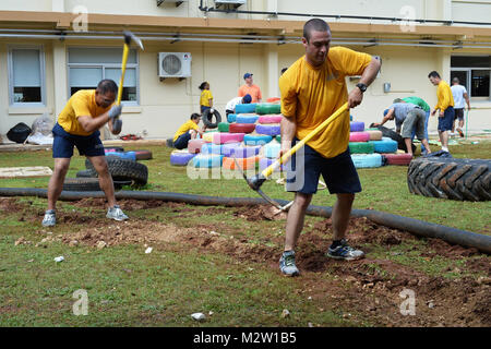 140303-N-PD757-505 BARRIGADA, Guam (3. März 2014) Maschinen Mechaniker 2. Klasse Rey Taa, links, und Maschinist Mate Feuerwehrmann Alfred Abate Einsatz Spitzhacken zu harten Korallen Boden durchbrechen, während einen Drainage Graben an der Guahan Akademie-Charter-Schule. Beide Segler sind aus dem u-Boot-tender USS Frank Cable (AS 40) und half Build einen Spielplatz gebaut ganz aus gespendeten recycelten Materialien. Frank Cable, nach vorn auf der Insel Guam bereitgestellt führt Wartungs- und u-Boote und Überwasserschiffe eingesetzt in den USA 7. Flotte Aufgabengebiet. (US Navy Foto b Stockfoto