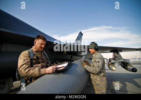 Us Air Force Oberstleutnant Bradford Everman, einer F-16C Fighting Falcon Pilot, funktioniert ein pre-flight Briefing mit Airman First Class Jeffrey Montemurro, einer F-16C Mannschaft Leiter, am Feb 5, 2011 at Bagram Air Field, Afghanistan. Everman ist der Kommandant der 119 Expeditionary Fighter Squadron, und Montemurro ist die 455th Expeditionary Aircraft Maintenance Squadron zugeordnet. Beide sind von der 177th Fighter Wing, New Jersey Air National Guard, die am Atlantic City International Airport, N.J. entfernt wird bereitgestellt Die 177Th bereitgestellt werden Koalition schließen Air Support zur Verfügung zu stellen. New Jersey Natio Stockfoto