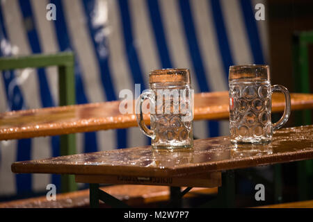 Leere Bierkrüge auf nassen Bier Tabellen, Oktoberfest, München Stockfoto