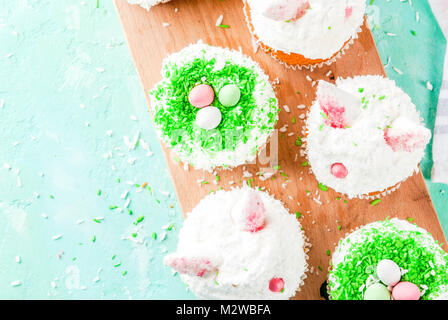 Ostern Cupcakes mit Hasenohren und Candy Eier, Raum oben Ansicht kopieren Stockfoto