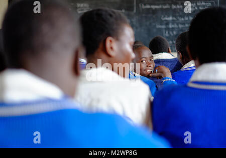 Kibuye/Ruanda - 08/26/2016: Lehrer und Schüler in Mathematik Unterricht in einem Klassenraum in einer Schule in Afrika. Eine Tafel und Kreuz können im b gesehen werden. Stockfoto