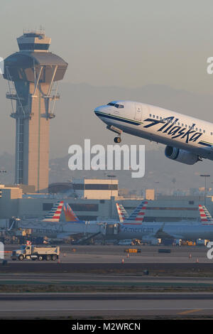 Alaska Airlines Boeing 737-900ER, Jet Airliner, vom Start- und Landebahn 25 am Los Angeles International Airport, der Tower hinter sich gelassen. Stockfoto