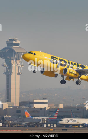 Spirit Airlines helle gelbe Airbus A320 vom Los Angeles International Airport, der Flugverkehrskontrolle im Hintergrund. Stockfoto