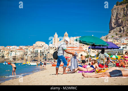 CEFALU, Sizilien - SEP 16,2014: Nicht identifizierte Personen am Sandstrand in Cefalu, Sizilien, Italien am 16.September 2014. Cefalu ist eine attraktive Altstadt und See Stockfoto