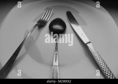 Weiße große leere Porzellan Teller mit Messer, Gabel und Löffel für Service Tisch für das Abendessen vorbereiten Stockfoto