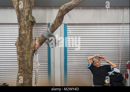 27.01.2018, Singapur, Republik Singapur, Asien - ein Mann sitzt an einem öffentlichen Platz neben dem Buddha Zahns Tempel in Singapur Chinatown. Stockfoto