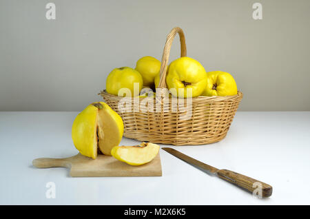 Zusammensetzung der Korb von Quitten auf einem weißen Tisch Stockfoto