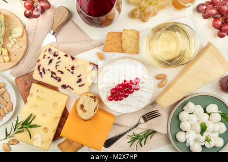 Verschiedene Arten von Käse mit Wein auf einem hellen Hintergrund Stockfoto