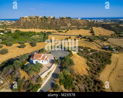 Antenne Vogelperspektive von Saint George Kapelle (parekklisi Agiou Georgiou) in Germasogia Gemeinde, Limassol, Zypern auf einem Hügel durch das Meer im Heu f Stockfoto