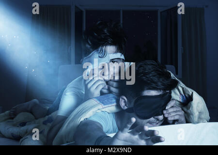 Angst und schlaflose Jungen kauen Fingernägel im Schlafzimmer vor der glänzenden Mond Stockfoto