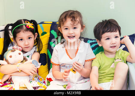 Glückliche Kinder spielen auf dem Bett Stockfoto