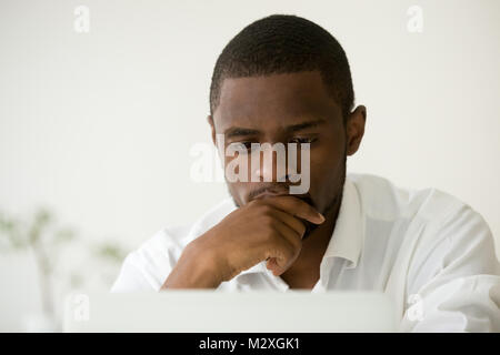 Afrikanische amerikanische Manager Arbeiten am Laptop Denken schwer der Problem Lösung fokussiert, konzentriert schwarze Unternehmer über die Arbeit betreffende Task, beschäftigt s Stockfoto