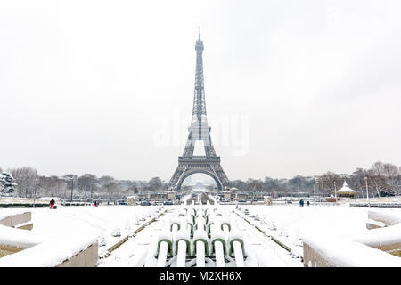 Winter in Paris im Schnee. Der Eiffelturm mit dem Wasserwerfer der Trocadero Brunnen im Schnee im Vordergrund verdeckt. Stockfoto