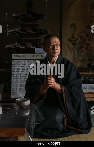 Sehr elegant Saß in seinem schwarzen, fliessende Roben, die einzige Mönch der winzigen Senko-ji Tempel, Herr Obayashi, meditiert, in den Bergen in der Nähe von Kyoto, Japan Stockfoto