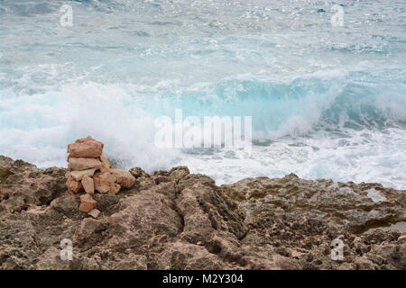 Türkis wave spritzt kleine Cairn und Ufer am Cap de Ses Salines im Süden Mallorcas. wave spritzt Ufer am Cap de Ses Salines, South Majo Stockfoto