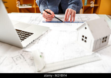 Junge weibliche Architekt und Designer arbeiten an Blueprint Projekt der neuen Wohnungen. Fotokonzept Arbeit auf technischen Zeichnungen Stockfoto