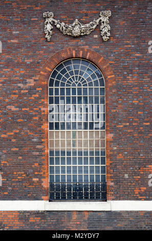 London, England, Februar 2018, mit Blick auf ein hohes Bogenfenster mit dekorativen Girlanden über ihm. Stockfoto