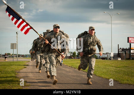 Spc. Michael Hons (rechts) und Sgt. Scott Jenson Der 191St Military Police Company nehmen an den gefallenen Soldaten Memorial 12 K laufen, beim Tragen der vollständige Bekämpfung Ausrüstung und die amerikanische Flagge. Der Lauf fand in Devils Lake, N.D. Am 23. Juni 2012 statt. (U.S. Army National Guard Foto: Sgt Brett Miller, 116 Öffentliche Angelegenheiten Loslösung) (Freigegeben) die Gefallenen 12 K durch die National Guard laufen Erinnern Sie sich Stockfoto