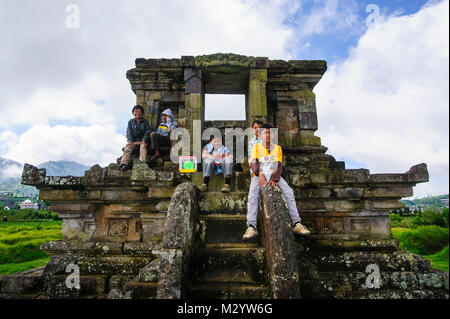 Jungen Jungen sitzen in einem Tempel des Arjuna Hindu Dieng Tempel Komplex, Dieng Plateau, Java, Indonesien Stockfoto