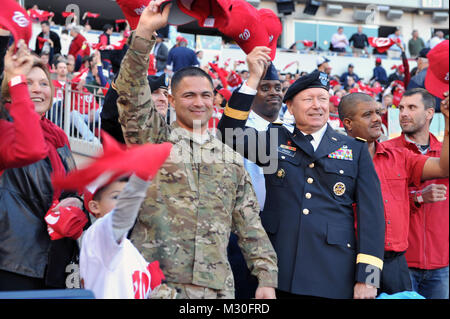 Armee Sgt. Hector Banda, eine aktive Pflicht Soldat mit der Armee V Corps, überrascht seine Familie vor einer Kapazität Masse an der Washington Nationals baseball spiel bei Nationals Park in Washington, D.C., am 11.10.2012, durch die Wiedervereinigung mit Ihnen beim Spiel am Tag nach flog er über Nacht von einem Einsatz in Afghanistan. Armee Gen. Frank Gras, der Chef der National Guard Bureau, Vertreter der National Guard am Spiel, war unter denen, die Banda home Willkommen geheißen. (Army National Guard Foto von Sgt. 1. Klasse Jim Greenhill) CNGB begrüßt ein Soldat der Nationalgarde Stockfoto