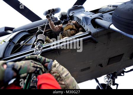 Us Air Force Staff Sgt. Brandon Taylor, ein 33 Rescue Squadron Bordmechaniker, Hebezeuge simulierten Überlebenden in ein 33 RQS HH-60 Pave Hawk als Teil einer Suche und Rettung Szenario für Übung Pacific Thunder 2012 in der Nähe von Osan Flughafen, Republik Korea, Okt. 15, 2012. Pacific Thunder ist eine jährlich stattfindende zweiwöchige Übung, die der 33. und 31. rqs von Kadena AB, Japan, und der 25 Fighter Squadron aus Osan Flughafen. Diese Einheiten arbeiten zusammen Suche und Rettung Taktiken zu üben für echte Notfälle vorzubereiten. (U.S. Air Force Foto/Staff Sgt. Sara Csurilla) Pave Hawk Stockfoto