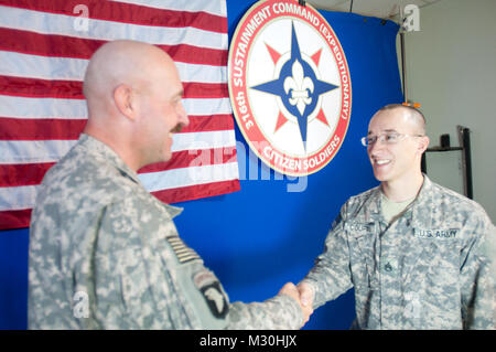 Chief Warrant Officer 2 Michael Godfrey gibt der Eid der Rekrutierung zu Staff Sgt. Jonathan Coupal, ein Bewohner von Rouses Point, N.Y., reenlists in der United States Army in Camp Arifjan, Kuwait (US Army Foto von Sgt. 1. Klasse Adam Stein, 316 Sustainment Command (Auslandseinsätze)) Staff Sgt. Jonathan Coupal Reenlistment von 316 ESC Stockfoto