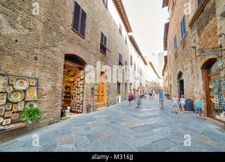 SAN GIMIGNANO (SI), Italien - 30. AUGUST 2017: Touristen einkaufen gehen in der Straße von San Gimignano, mittelalterliches Dorf in Italien Stockfoto