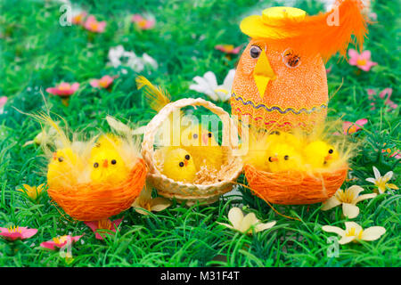 Ostern Einstellung mit Hühnern und Ei auf Gras Hintergrund. Stockfoto