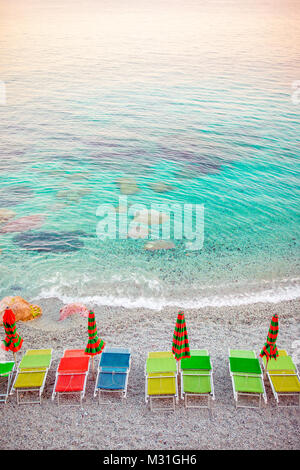 Sonnenliegen und Sonnenschirme an der europäischen Küste in Monterosso, Cinque Terre, Italien Stockfoto