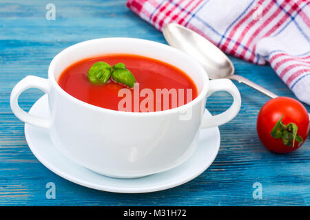 Cremesuppe von frischen roten Tomaten auf Blau Holz- Hintergrund Stockfoto