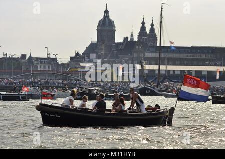 Amsterdam, Niederlande - 23 August 2015: Zuschauer in einem Pkw Boot Kreuzfahrt im Hafen von Amsterdam Ijhaven zum Zeitpunkt der Sail 2015 Stockfoto