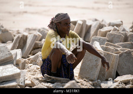 Eine ethnische Ferne Mann nimmt einen Bruch von Bergbau Salz in die Danakil-wüste in Äthiopien. Stockfoto