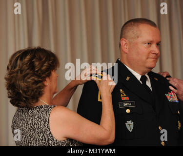 Armee Brig. Gen. William L. Smith Lächeln, da seine Frau, Col (Ret.) Cindy Smith, Stifte auf der Schulter Mainboards mit zwei Sterne während seiner Beförderung zum Major General im Camp Mabry, in Austin, Texas, 24. Juni 2013. Smith wurde vor kurzem von Texas reg ernannt. Rick Perry, wie der Assistent Adjutant General für die Armee zu dienen. (National Guard Foto Illustration von Army Staff Sgt. Jennifer D. Atkinson/Freigegeben) (Dieses Bild wurde beschnitten, auf das Thema des Bildes zu konzentrieren.) 130624-Z-JR 121-014 Generalmajor William L. von Texas militärische Abteilung Stockfoto