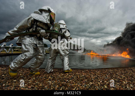 Feuerwehrmänner Manöver einem Feuerwehrschlauch Brände in Angriff zu nehmen, zur Unterstützung der Krieger Übung 86-13-01 (Warex) Übung/Global Medic 2013, Fort McCoy, Wis., 27. Juli 2013. WAREX bietet Einheiten die Möglichkeit, militärische Manöver und Taktiken zu üben. Gehalten in Verbindung mit Warex, Global Medic ist ein jährlicher Gemeinsamer-field Training übung für alle Aspekte des Theaters bekämpfen medizinische Unterstützung zu replizieren. (U.S. Air Force Foto: Staff Sgt. Jared Becker/Freigegeben) 130727-F-HV 225-788 durch den Befehl Leiter der Air National Guard Stockfoto