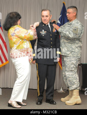 Generalmajor Manuel A. Rodriguez VII, Kommandant der Texas State Guard, und Frau Yolanda Garza pin Carlos Garza, Texas State Guard, der Brevet Brigadegeneral während der Werbeaktion Zeremonie am Lager Mabry, in Austin, Texas, 27. Juli 2013. Garza zog sich vom Texas Army National Guard nach 30 Jahren im Dienst, und seitdem hat sich mit der Texas State Guard für neun Jahre gedient. (U.S. Army National Guard Foto von Armee Cpt. Martha Nigrelle) 130727-Z-FP 744-063 Brig. Gen. Garza, Texas State Guard, Förderung von Texas militärische Abteilung Stockfoto