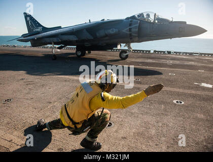 130804-N-KE 519-045 CORAL SEA (Aug. 4, 2013) der Luftfahrt Bootsmann Mate (Handling) 1. Klasse Jawara Lockett Signale der Pilot eines AV-8B Harrier aus dem schwarzen Schaf der Marine Attack Squadron (VMA) 214, dass er gelöscht wird für den Start des Flight Deck des Amphibious Assault ship USS BONHOMME RICHARD (LHD6). Bonhomme Richard ist das Flaggschiff der Bonhomme Richard amphibische Gruppe und bereit, mit der begonnen 31 Marine Expeditionary Unit, derzeit die Routine der gemeinsamen Kraft arbeiten in den USA 7 Flotte Bereich der Operationen. (U.S. Marine Foto von Mass Communication Specialist Seama Stockfoto