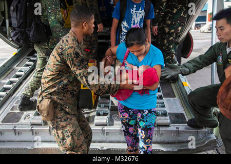 131112-M-GX 379-618 MANILA, Philippinen (Nov. 12, 2013) US Marine Lance Cpl. Xavier L. Cannon und die Mitglieder der philippinischen Streitkräfte um Zivilisten, die durch Taifun Haiyan aussteigen der C-130 Flugzeugen an Villamor Air Base. Us-Mitglieder unterstützen die Streitkräfte der Philippinen, wie Sie preform Wiederaufnahme Bemühungen für die Menschen in der Folge des Taifuns Haiyan betroffen. (U.S. Marine Corps Foto von Lance Cpl. Anne K. Henry/Freigegeben) uns Phi Streitkräfte um Zivilisten, die durch Taifun Haiyan durch # FIRMA PACOM Stockfoto