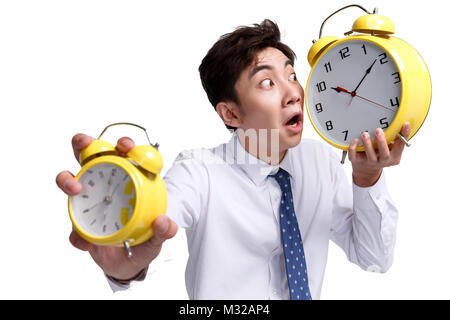 Schockierend business junger Mann mit einem Wecker Stockfoto