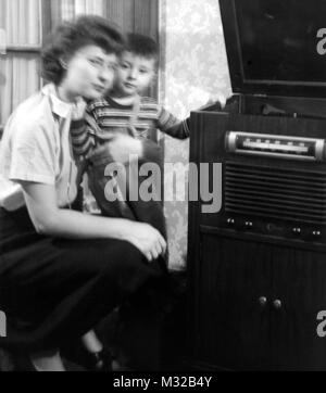 Eine junge Mutter und Sohn sind ein Unschärfe während Sie Radio hören, Ca. 1940. Stockfoto