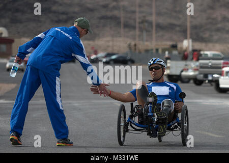 Christopher Aguilera Zyklen von Mike Sanders zu einem hohen - fünf erhalten, nachdem er beendete das Rennen am 9. April 2014, während der Air Force Studien an der Nellis Air Force Base, Nev Aguilera und Luftwaffe verwundete Krieger, zuerst in seiner Kategorie bei der Fertigstellung. (U.S. Air Force Foto/Senior Airman Jette Carr) 140415-F-GY 869-006 durch Luftwaffe verwundete Krieger Stockfoto